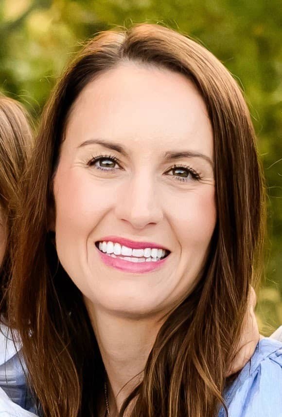 Lauren Roberts, vice president, secretary, and treasurer of B.G. Hoadley Quarries Inc., smiling outdoors in a light blue blouse with greenery in the background.